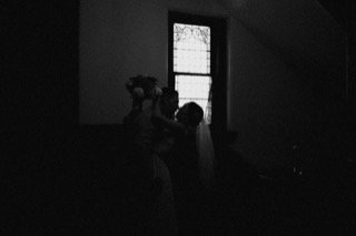 Ceremony: bride, groom, couple, dark, doorway, flower