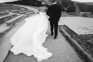 The Couple: amphitheater, wedding dress, bride, groom, cocktail dress, couple