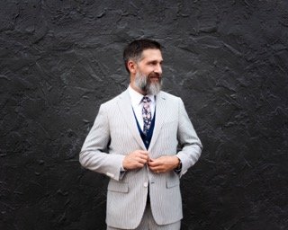 The Couple: adjust, beard, wall, business suit, dress, gray