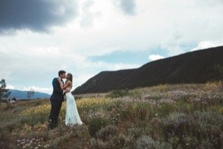 The Couple: bride, groom, couple, field, flower, hill