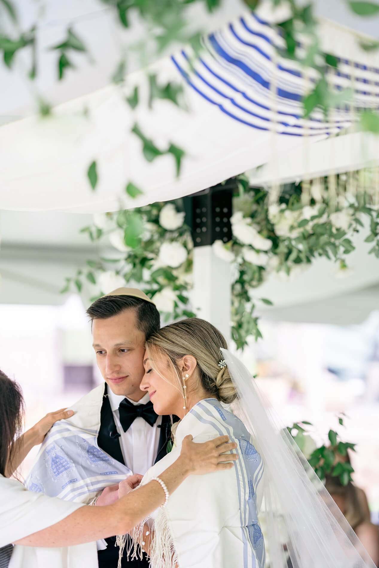 bride and groom with tallit prayer shawl under the chuppah
